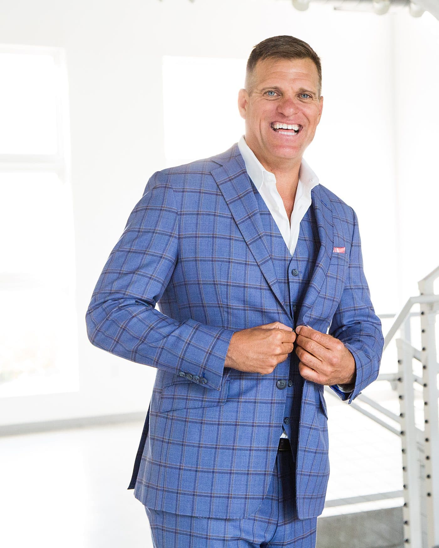 Dave VanHoose buttoning his jacket at the base of a staircase